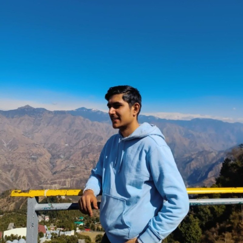 Dhruv Sangra in a blue hoodie against a mountain landscape